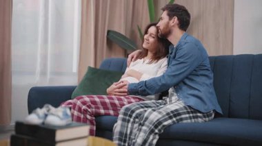 Karı koca, oturma odasındaki kanepede oturup bebek konuşması bekliyor. Aşk ilişkisi. Aileler.