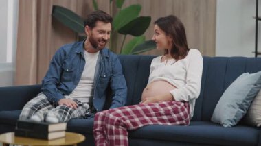 Aile sahnesi. Neşeli, sakallı bir adam, bebeğini dinlerken neşeli, genç ve güzel bir karısı vardı. Planlı hamilelik. Bakım ve destek.