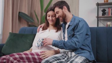 Aile hayatı. Müstakbel anne babaların bebek bekledikleri, koltukta oturup çocukları hakkında konuştukları sevimli bir sahne. Çocuk ayakkabıları. İlişki. Evlilik..