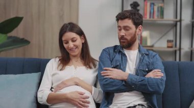 Mutlu hamile kız arkadaşı gülümserken başı dertte olan genç bir adam korkmuş hissediyor. Planlanmamış hamilelik. Sorunlar.