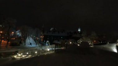 Akşam şehir merkezindeki FPV uçuşu. Karlı kış caddeleri. Gece şehri aydınlatması. Tatil atmosferi. Seyahat.