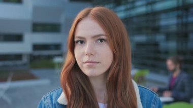 Modern kampüs kolej binasının yanında sırt çantası takan kızıl güzel bir kızın portresi. Eğitim. Modern gençlik.