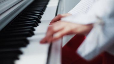 Piyanoyu ustalıkla çalan, müzikal tutku ve kültürel ifadelerin etkili bir şekilde sergilendiği ellerin yakın çekimi.