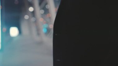 Bir figürün yakın plan görüntüsü, sanatsal açıdan güzel bulanık şehir arkaplanına karşıdır.