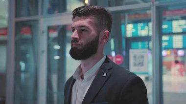 Dengeli bir iş adamı hareketli bir şehir ortamında duruyor, profesyonelliği ve güveni somutlaştırıyor..