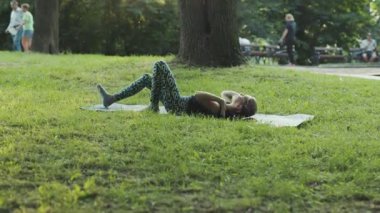 NEW YORK - 19 Nisan 2019: Manyetik genç kız parkta yoga yapıyor, Asya antremanının tadını çıkarıyor. Rahatlama. Fiziksel ve duygusal olarak iyi. Nefesine odaklan. Konsantrasyon. İlham dolu bir kız.