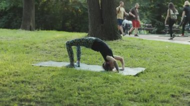 NEW YORK - 19 Nisan 2019: yoganın güzel bir unsuru. Central Park 'ta yoga yapan büyüleyici küçük bir kızın görüntüsü. Günlük rutin. Yaz zamanı. Dışarı çıkın. Stresi azalt