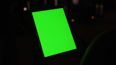 Dik tablet tablet taşıyan modern bilgisayar aygıtı kullanan genç bayan şehir kızı koyu arkaplanda yeşil ekran maketi. Gece vakti. İnsanlar ve teknoloji.