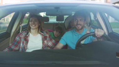 NEW YORK - 10 Haziran 2018: Mutlu ve sevgi dolu ebeveynler ve onların heyecanlı çocuklarının şehirde araba sürerken gülümsemesi. Genç aile yazın arabayla yurt dışına seyahat ediyor..