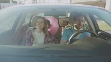 NEW YORK - 5 Nisan 2018: Mutlu aile deniz kenarına yaz yolculuğunun tadını çıkarıyor. Gülümseyen ailelerin ve çocukların önünde arabada oturarak gidecekleri yere gidiyorlar..