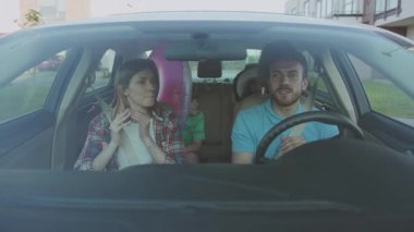 NEW YORK - 10 Haziran 2018: Yazın inanılmaz bir genç aile gezisi. Neşeli anne babaların ve çocukların dans edip şarkı söylemelerinin ve modern şehirde araba sürmelerinin ön görüntüsü..