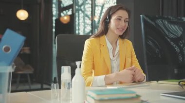 Kendine güvenen genç bayan ofis danışmanı kulaklıkla online görüntülü sohbet müşteri konferansı ya da uzak konferans eğitimi hakkında konuşuyor. İş konsepti.