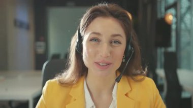 Güzel, zeki, beyaz bir kadın internetteki konferans görüntülü sohbet görüşmeleri ile kulaklık takıyor. İş görüşmesi yapıyor ya da uzak bir kursa gidiyor..