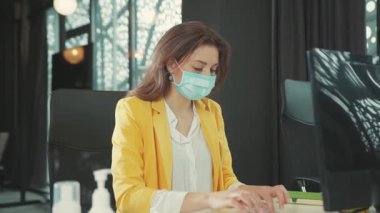 NEW YORK - 28 Mart 2020: Bilgisayar üzerinde çalışan tıbbi maskeli genç iş kadını ani baş ağrısı ve bitkin düşmüş bir ağrı hissetti. Maske korkusu. Temiz oksijen yok. Sağlık hizmetleri. Salgın.