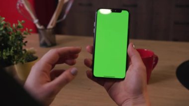 Tokio, Japonya - 7 Nisan 2018: Ev kahvaltının mutfağında dikey yeşil ekranlı akıllı telefonu kapatın, işyeri restoranlarında alışveriş yapan kızlar soyut yavaş çekimde internet alışverişi yapıyor.