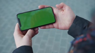 NEW YORK - 5 Nisan 2018: Yoğun sokak arkaplanı kaldırımında telefon tutan ağır çekimli kadın internet teknolojisi chroma anahtar mesajında sörf sayfalarını kaydırıyor