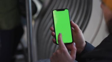 Lviv, Ukrayna - 19 Mayıs 2018: Ağır çekim kadın elleri, tramvay krom anahtar akıllı telefon teknolojisi cep telefonu sokak dokunma mesajında yatay yeşil ekranlı cep telefonu kullanmaktadır