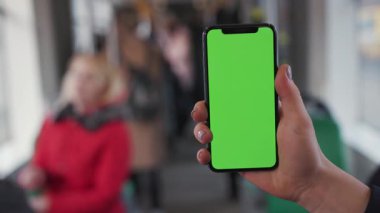 Lviv, Ukrayna - 19 Mayıs 2018: Kadın ellerini kapat ve tramvay krom anahtar akıllı telefon teknolojisi cep telefonu sokak mesajı yavaş çekimde dikey yeşil ekranlı cep telefonu kullan