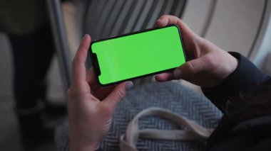 Lviv, Ukrayna - 19 Mayıs 2018: Genç kadın elleri, tramvaydaki yeşil ekranlı cep telefonu teknolojili cep telefonlu cep telefonu ile yavaş çekimde mesaj iletiyor