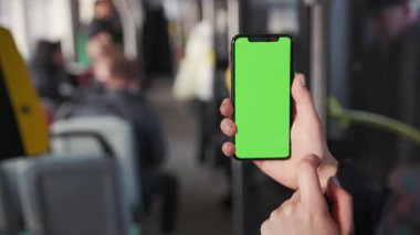 Lviv, Ukrayna - 19 Mayıs 2018: Kadın ellerini kapat ve tramvay krom anahtar akıllı telefon teknolojisi cep telefonu sokak mesajı yavaş çekimde dikey yeşil ekranlı cep telefonu kullan