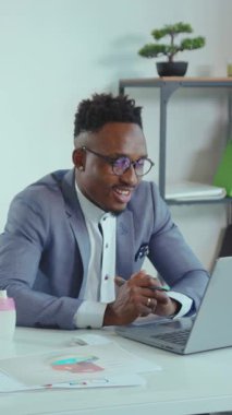 Video, masa başında takım elbiseli profesyonel bir adamın laptopuyla meşgul olduğunu, odak ve üretkenlik içeren kurumsal bir atmosfer taşıdığını gösteriyor.