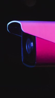 Gözetleme kamerasının detaylı bir yakın çekim görüntüsü, parlak neon ışıkları belirgin bir şekilde gösteriyor.