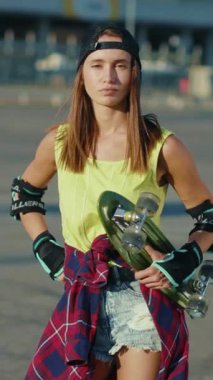 Ekose gömlekli ve şapkalı genç bir kadın kaykay yeteneklerini sergiliyor, maceraya hazır. Video onun şehir kaykayına olan tutkusunu yakalıyor.