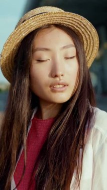 Göz kamaştırıcı, güzel, uzun saçlı, şık bir hasır şapka takan, şık, açık hava manzaralı bir kadın.