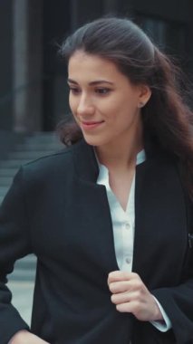 Kendine güvenen bir kadın kıyafetlerini düzeltiyor, profesyonel bir çevreye özgüven yayıyor.