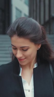 Parlak bir gülümsemesi olan kendine güvenen genç bir kadın açık havanın tadını çıkarıyor, canlı modasını ve pozitifliğini sergiliyor.