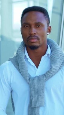 Hoş bir süveter giymiş şık bir adam, modaya uygun bir yerde, inkar edilemez bir güven ve cazibe yayıyor.