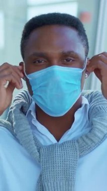 Rahat bir süveter ve mavi bir maske giyen genç bir adam, modern sağlık eğilimlerini gözler önüne seriyor.