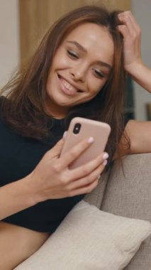 Genç bir kadın, akıllı telefonuyla neşe içinde modern hayatın özünü yakalıyor.