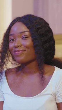 Şaşırtıcı derecede güzel, kıvırcık saçlı, sakin ve zarif bir yan görünüşü olan genç bir kadın.