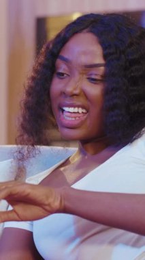 Modern bir ortamda kıvırcık saçlı düşünceli bir kadın bir dizi duygu ve ifade sergiliyor.