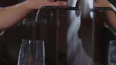 Ellerini kapat kadın musluğun altına bir bardak getirir ve filtrelenmiş su döker. Sağlık suları. Sanatoryumlar. Yavaş çekim