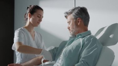 Kadın doktor ışık odasında hastadan kan almaya hazırlanıyor. Kan bağışı. Donör adam gülümsüyor. İlaçlar. Laboratuvar. Yavaş çekim