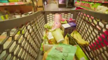 Alışveriş zamanının videosu süpermarket manzaralı yiyecek dolu bir alışveriş arabası. Enflasyon. Tüketici sepeti. Kriz. Satın alma gücünde azalma