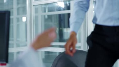 Tıp bürosundaki masada oturan yorgun, üzgün genç adam muayene sırasında yapılan hamlelerin röntgenlerine bakarak kadın doktorla konuşuyor. Kapatın. Yavaş çekim