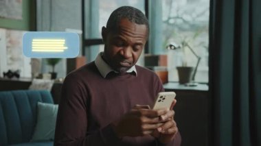 Bir adam cep telefonuna dalmış, koltukta dinleniyor. Onun ifadeleri, eğlenceden meraka, teknolojinin boş zamanlardaki rolünü vurguluyor.