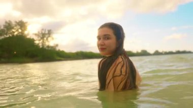 Bu sakin videoda, bir kadın sersemletici su ortamlarında, barışçıl anlarda ve zarif yüzmede doğa ile olan bağını gösteriyor.