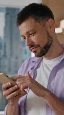 Şık bir adam, canlı bir şehirde, modern bir yaşam tarzını teknolojiyle yansıtan akıllı telefonuyla meşgul olur.