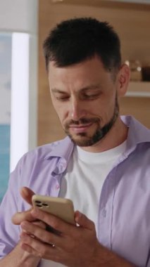 Bir adam akıllı telefonunu şehir arka planına doğrultuyor, günümüz dünyasında modern teknolojiyi sergiliyor.