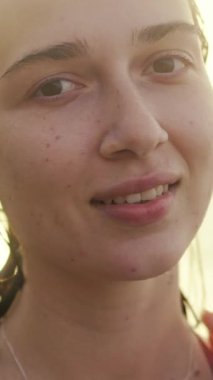 Huzurlu bir kadın, sıcak, yumuşak bir ışığa dalmışken bir anlık saf sükunetin tadını çıkarıyor.