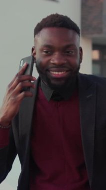 Bu ilgi çekici videoda, iyi giyimli bir adam mesajları kontrol ederken profesyonelliğini gösteriyor ve neşeli bir telefon görüşmesi yapıyor, iş ve kişisel bağlantıyı sorunsuzca karıştırıyor.