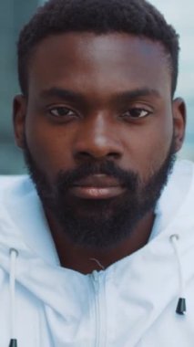 Şık, beyaz bir ceket giymiş düşünceli bir adam modern bir arka plana karşı derin düşüncelere dalmış.