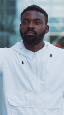 Şık beyaz ceket giyen bir adam canlı, canlı bir şehir ortamında kendine güven ve karizma yayar.