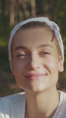 Doğanın tadını çıkaran neşeli bir kadın, saç bandı takıyor ve gülümsüyor. Yaşam tarzı temaları için mükemmel.