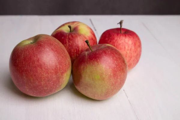 beyaz bir tahta üzerinde dört kırmızı elma