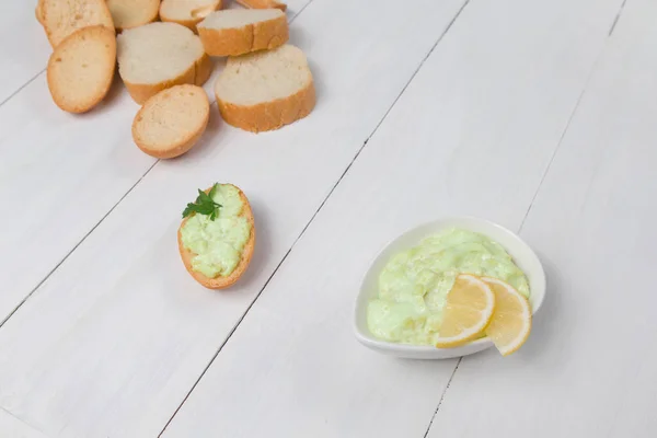 Ahşap arka planda kıtır ekmekli avokado sosu düzgün yemek vejetaryenliği fotoğrafı.